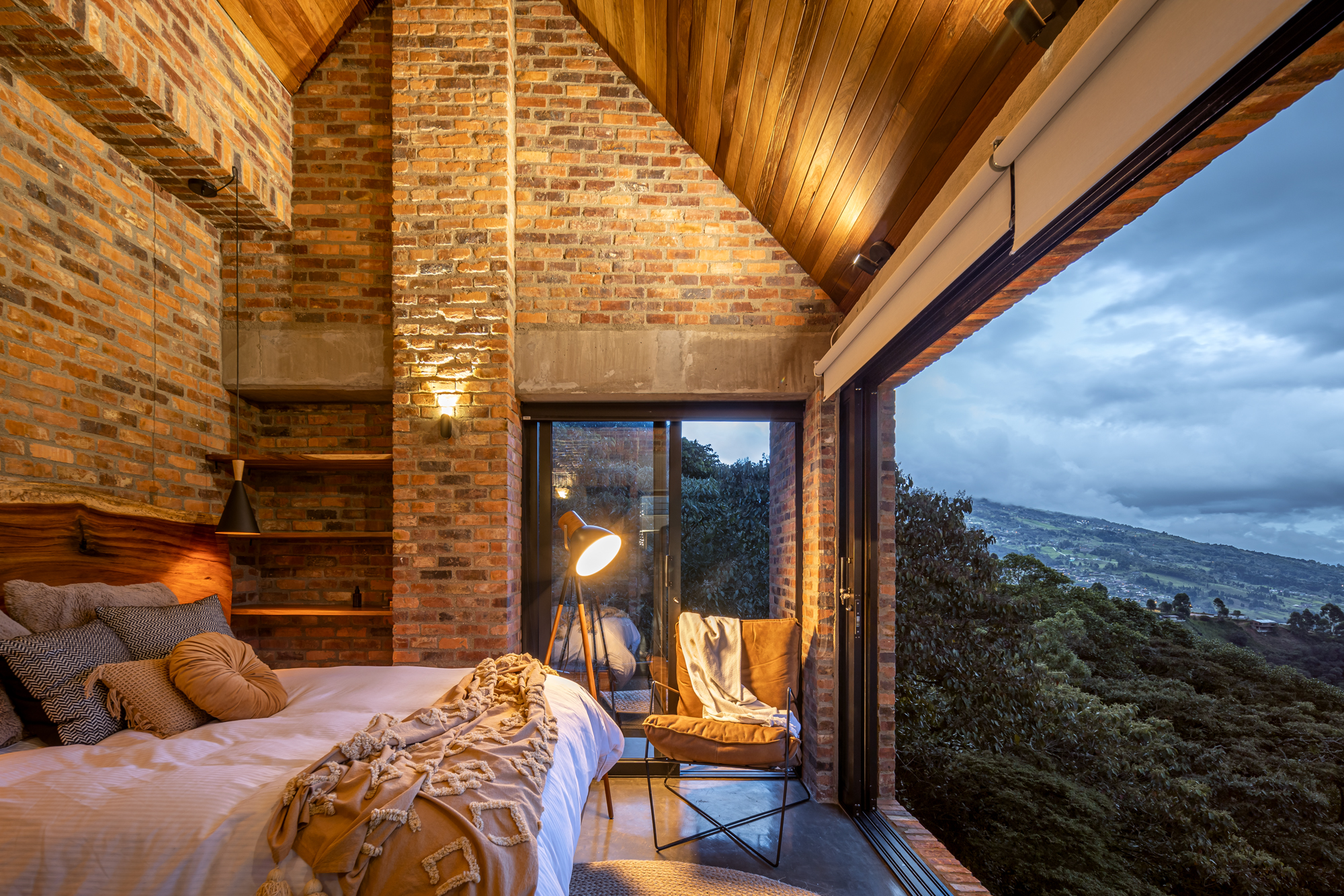 Habitación de muros en ladrillo con cielo raso en listones de madera