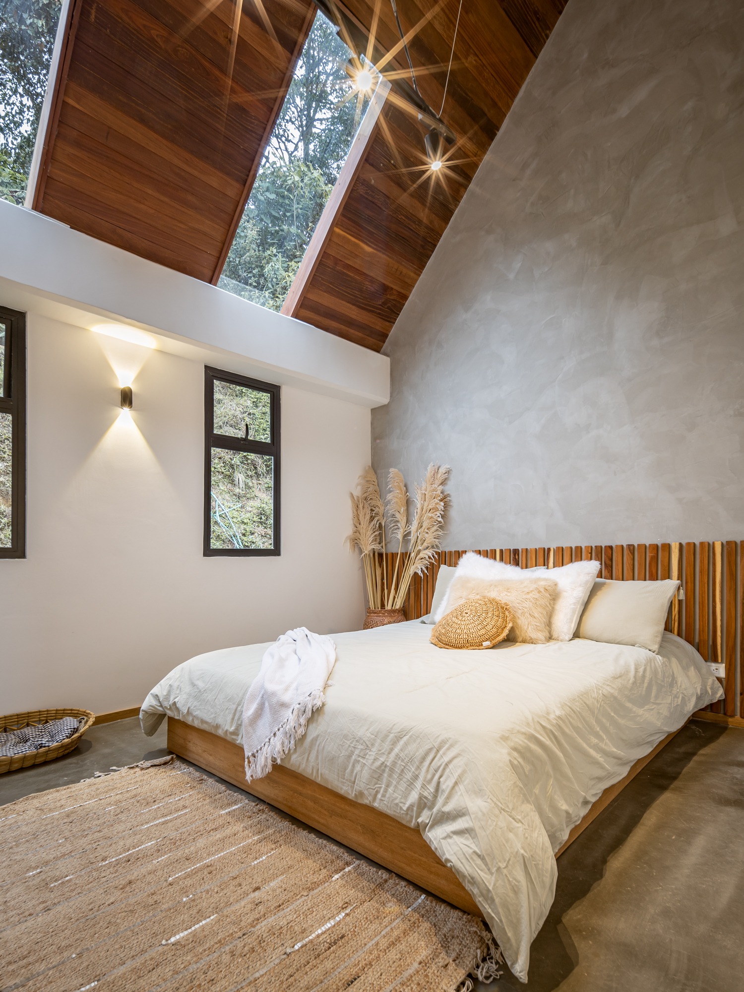 Habitación con cielo raso a dos aguas, claraboyas y muros en microcemento